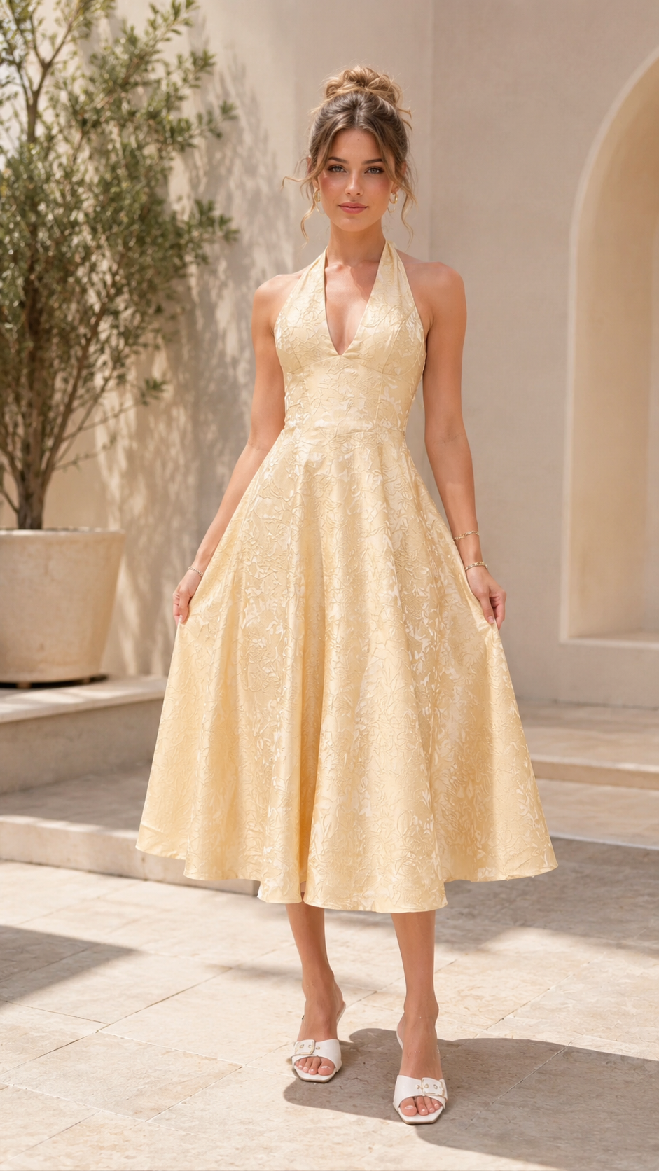 Front view of champagne halter midi A-line dress with textured finish