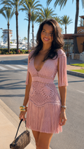 Blush pink crochet fringe mini dress with deep V neckline and tassel hem front view