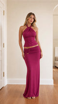 Model wearing fuchsia halter top and maxi skirt set from front