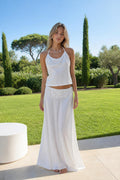 Front view of model wearing white satin halter top and maxi skirt set