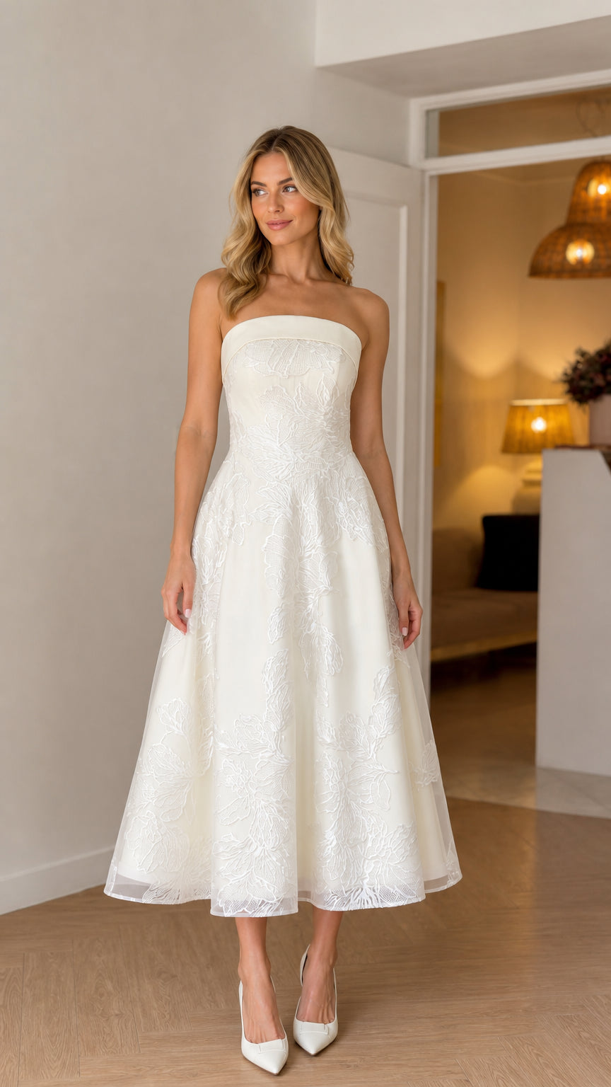 Front view of model wearing white strapless floral embroidered midi dress