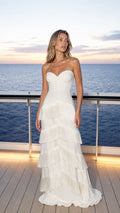 Front view of model wearing white tiered fringe strapless maxi dress