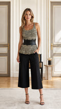 Front view of model wearing olive textured knit peplum tank top with black belt and cropped trousers