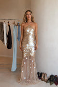 Front view of model wearing the champagne sequined halter maxi dress