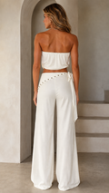 Model wearing white strapless top and wide leg pants set from the back