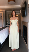 Front view of woman wearing light yellow ruffled maxi dress