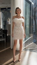 Model wearing white strapless feather mini dress front view
