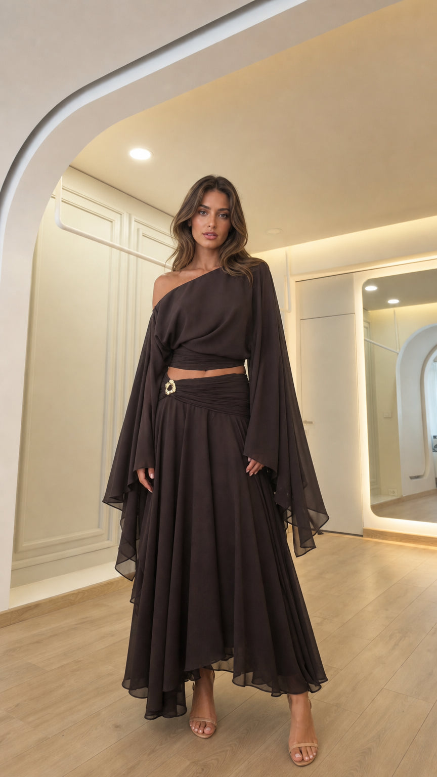 Front view of woman wearing dark brown off-shoulder crop top and matching maxi skirt set