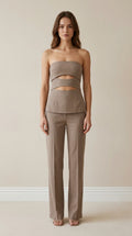 Front view of model wearing taupe strapless cut-out top and trousers set