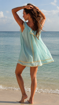 Back view of aqua sleeveless ruffle neck beach cover up mini dress on the shore