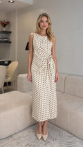 Front view of cream polka dot midi dress with waist tie