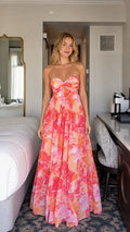 Front view of model wearing pink floral strapless maxi dress
