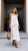 Front view of white lace trim cami top and midi skirt set with woven tote and sandals