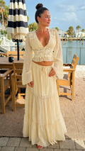 Front view of cream lace crop top and tiered maxi skirt two-piece set with sheer sleeves