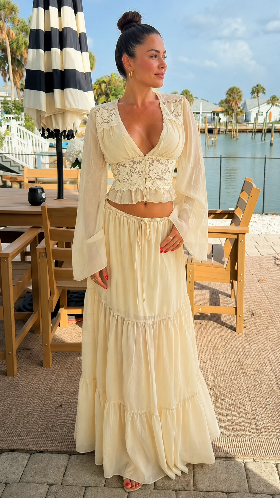 Front view of cream lace crop top and tiered maxi skirt two-piece set with sheer sleeves
