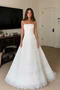 Front view of white strapless tiered lace evening dress
