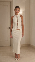 Model wearing ivory crystal embellished halter top and midi skirt set from front