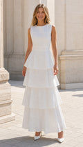 Front view of woman wearing white tiered eyelet maxi dress