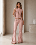 Model wearing a blush pink ruched cap-sleeve crop top with matching fringe flare pants front view
