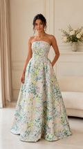 Front view of pastel floral strapless ball gown maxi dress with full skirt and pockets