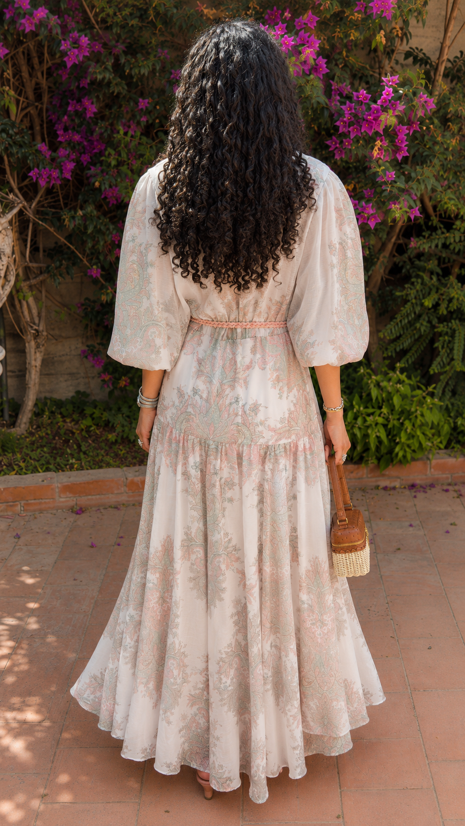 Back view of blush ivory floral maxi dress with flowing tiered skirt and puff sleeves