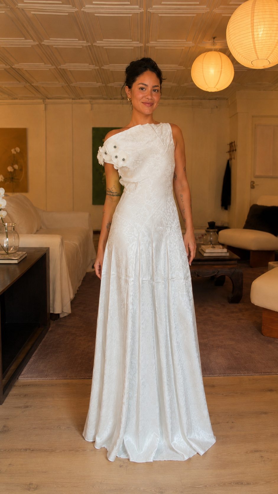 Front angle view of white textured one-shoulder floor-length gown