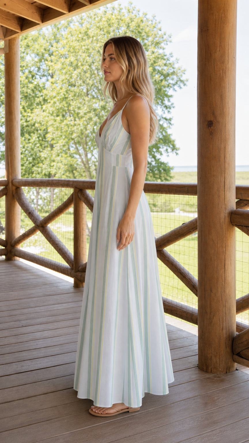 Side profile view of woman wearing white striped maxi dress