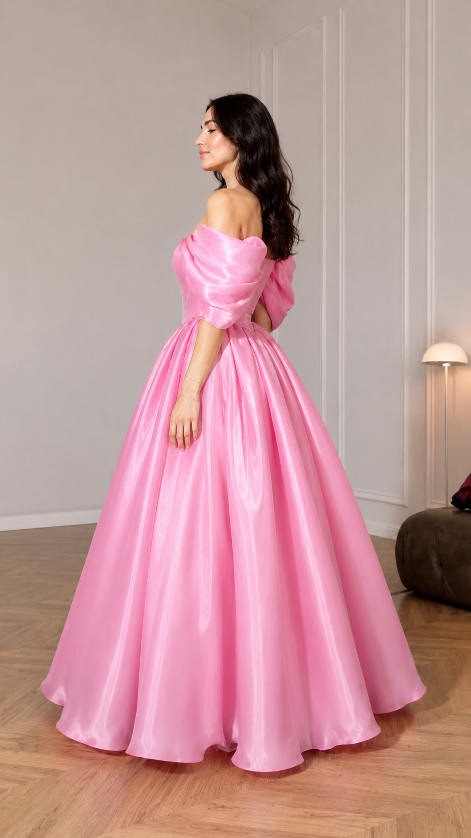 Side view of pink formal ball gown with voluminous skirt and off shoulder sleeves