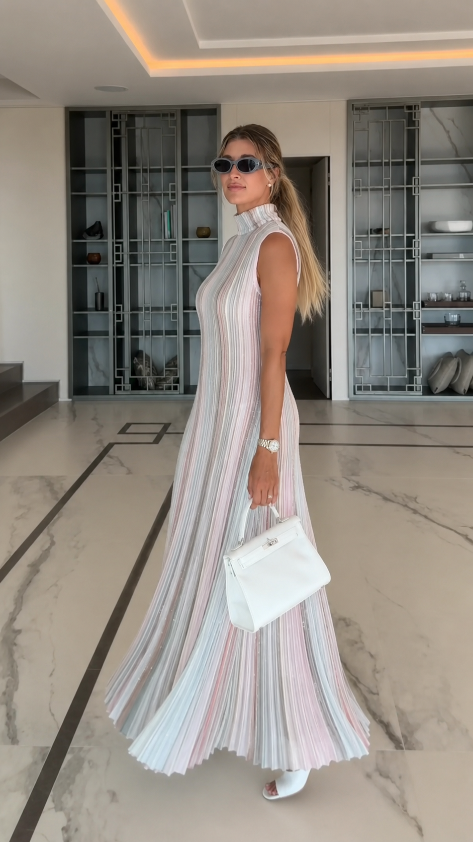 Side view of pastel multi pleated sleeveless maxi dress with flowing hem