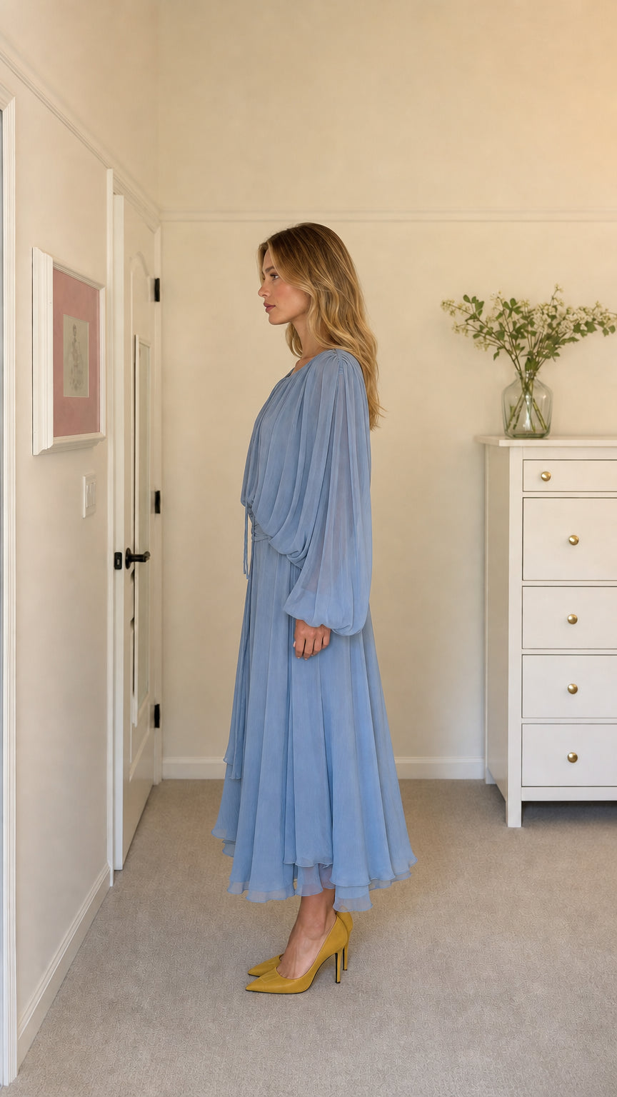 Side profile of model in light blue pleated midi dress