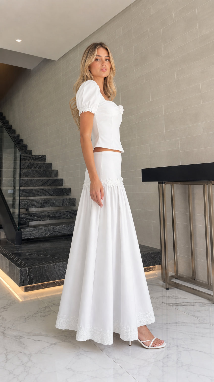 Side profile of model in white two-piece maxi set