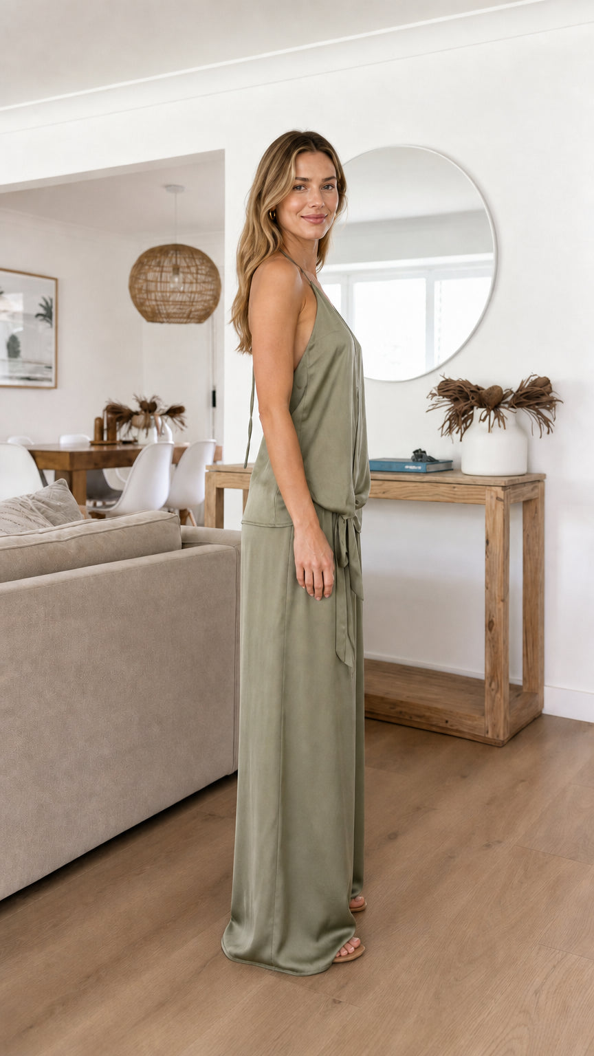 Model posing sideways in sage green satin two piece set