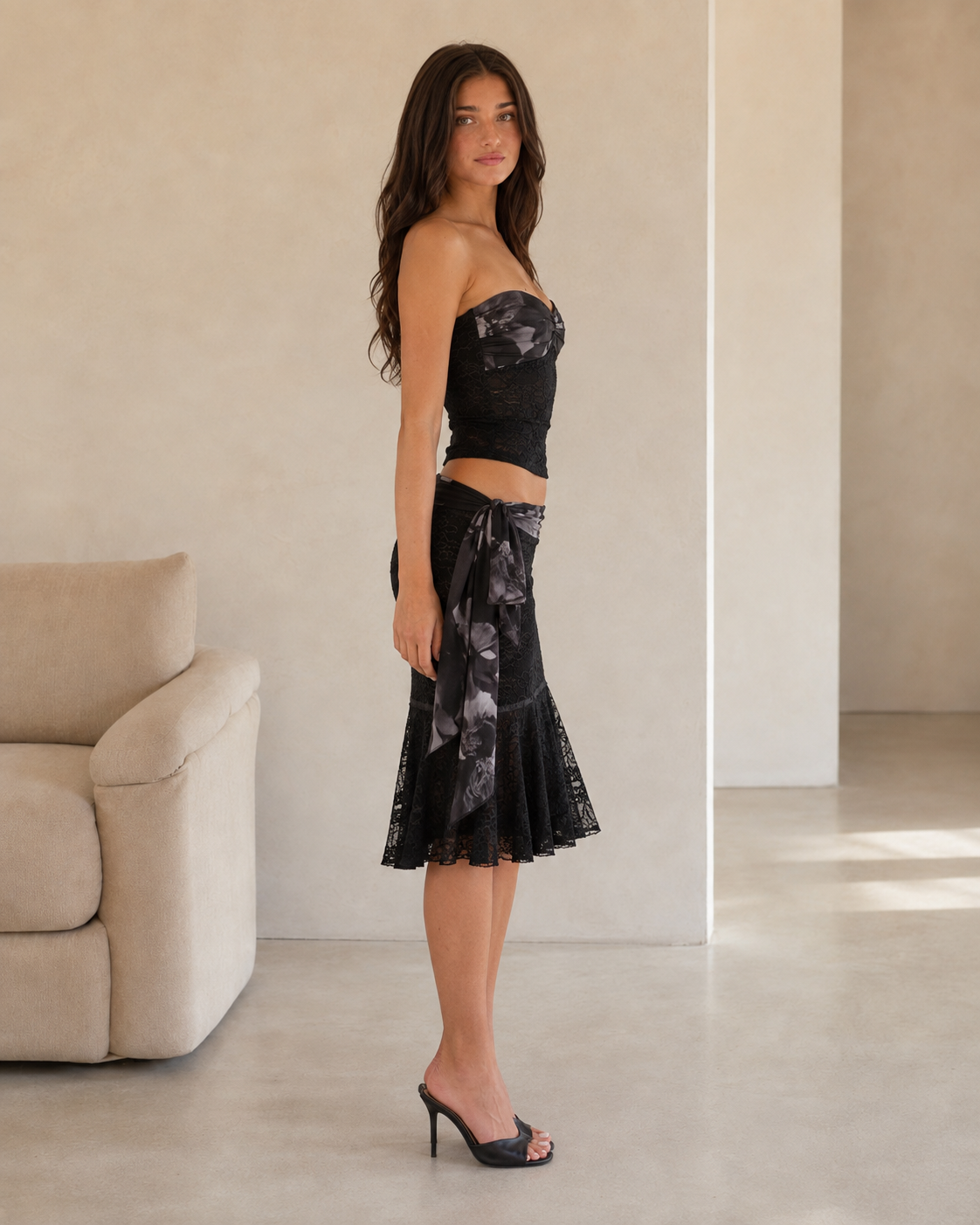Side profile view of model wearing black floral lace two-piece set