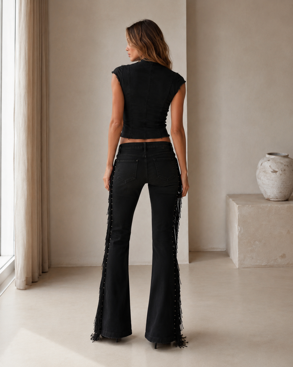 Back view of the black matching set with fitted cap-sleeve top and fringe flare pants