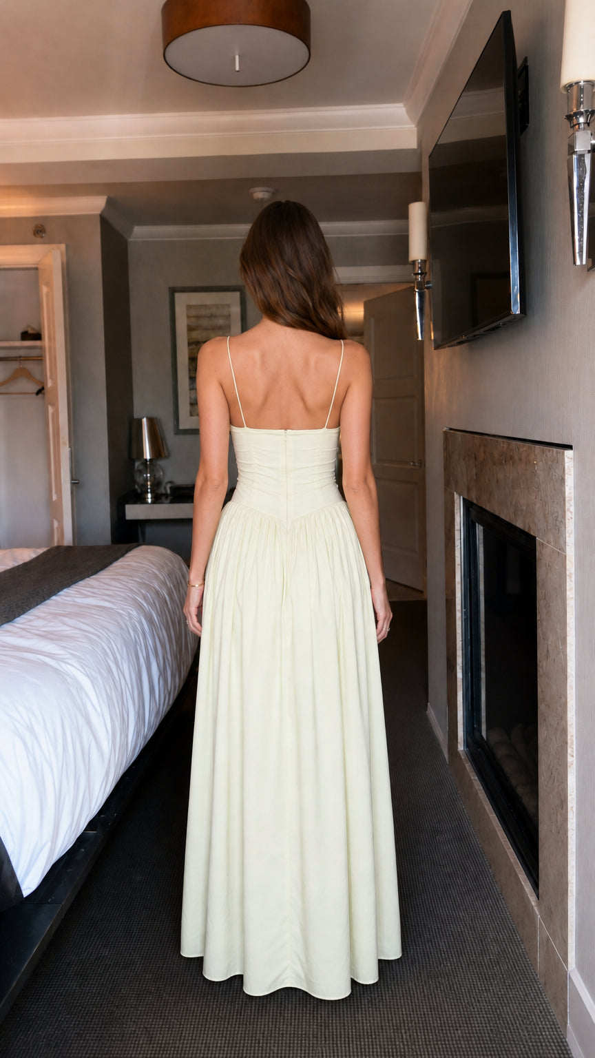 Back view of woman wearing light yellow ruffled maxi dress