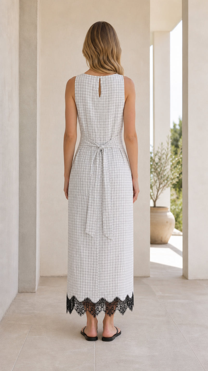 Back view of model in white gingham midi dress showing self-tie sash