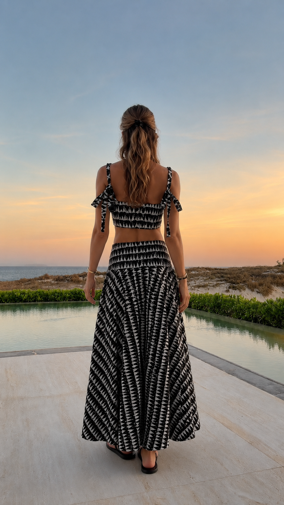 Back view of black printed two-piece maxi skirt set with tie shoulders