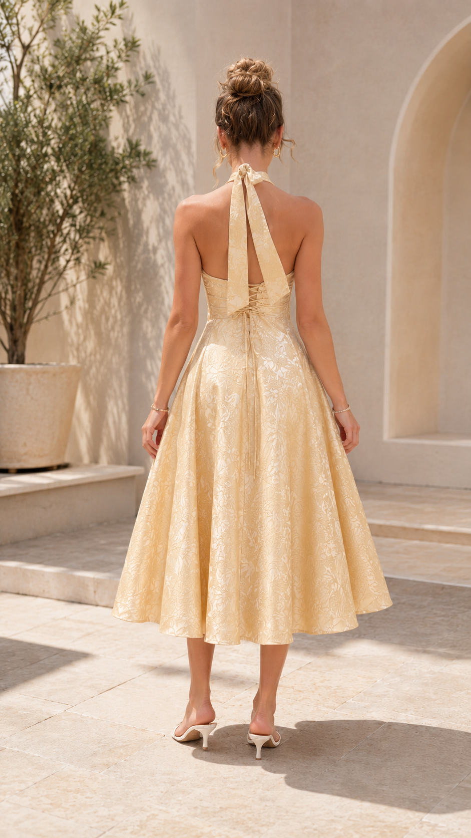 Back view of champagne open-back halter midi dress
