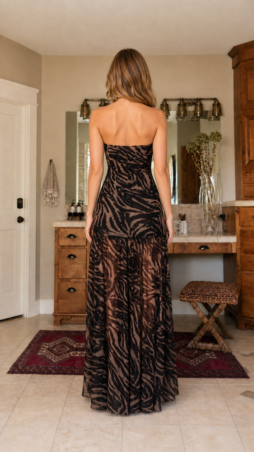 Back view of model in brown zebra print strapless maxi dress