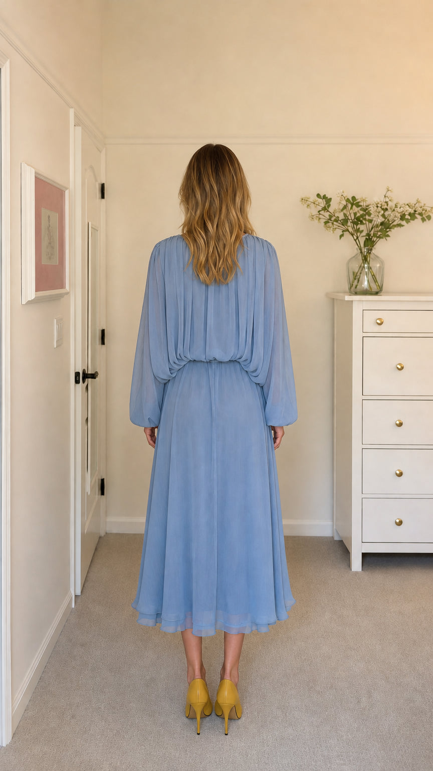 Back view of model in light blue pleated midi dress