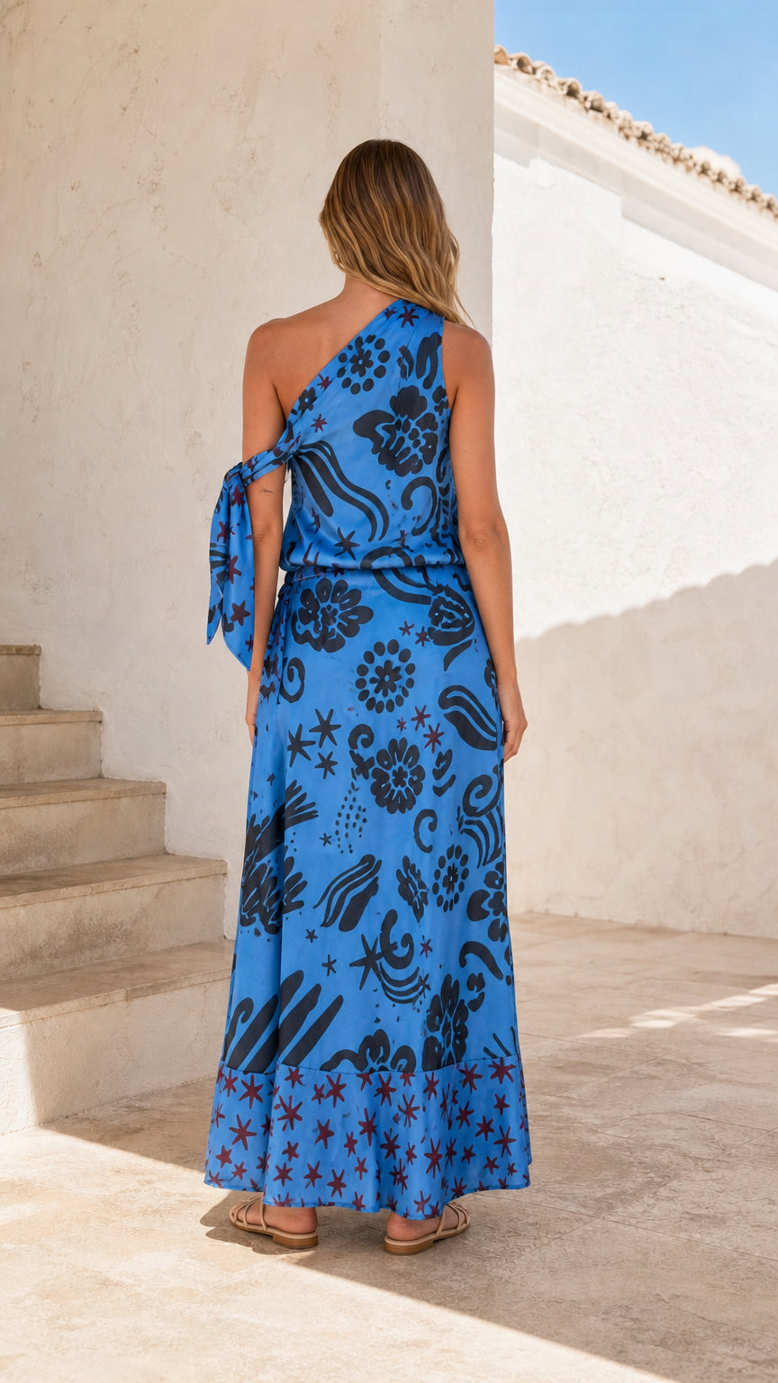 Back view of bright blue one-shoulder maxi dress showing shoulder tie