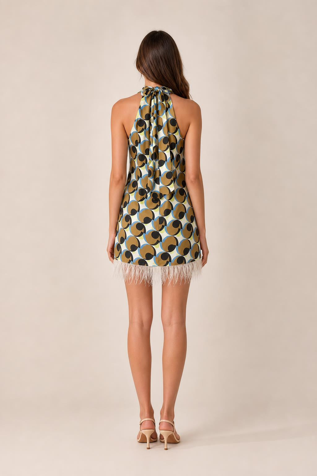 Back view of model wearing geometric halter mini dress