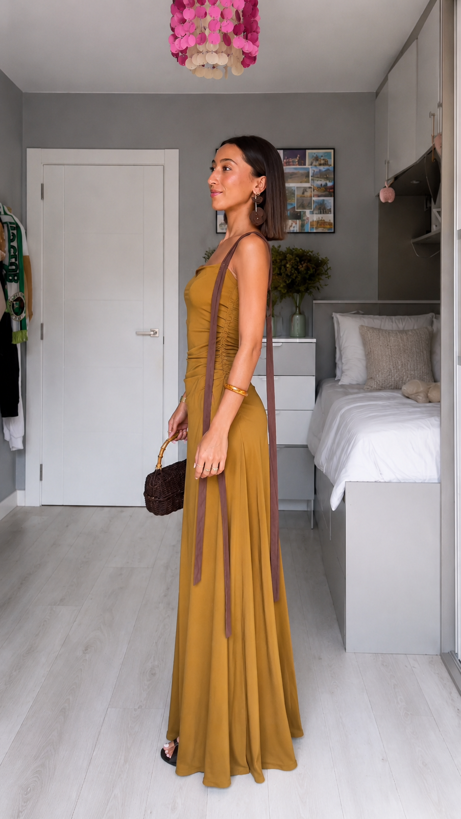 Side view of mustard sleeveless maxi dress with flowing skirt and ribbon strap detail