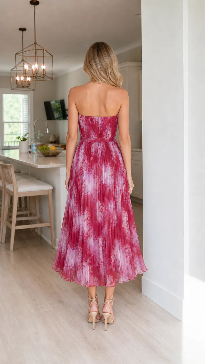 Back view of woman in fuchsia pleated midi dress