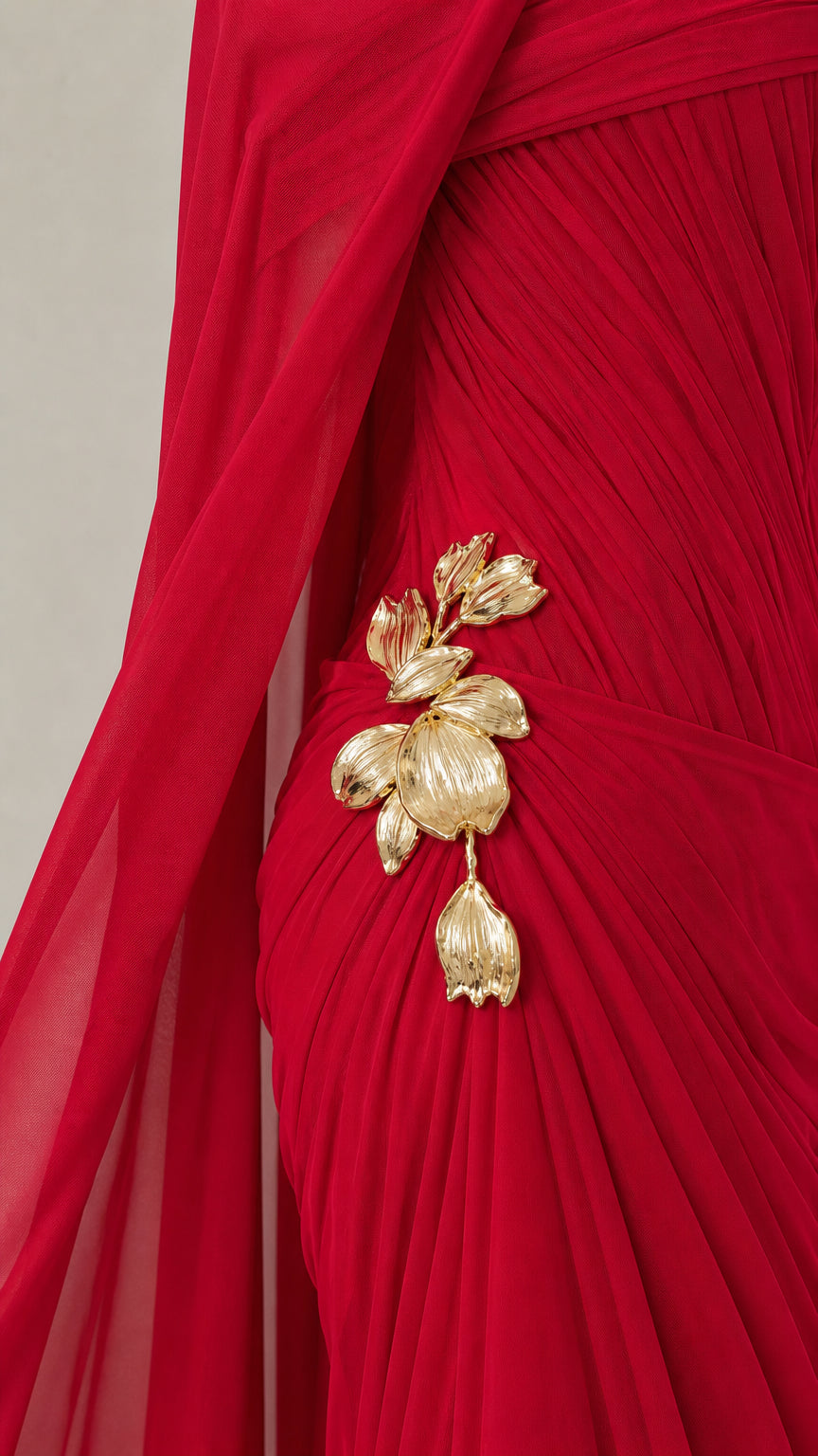 Close-up detail of gold floral brooch on red draped fabric