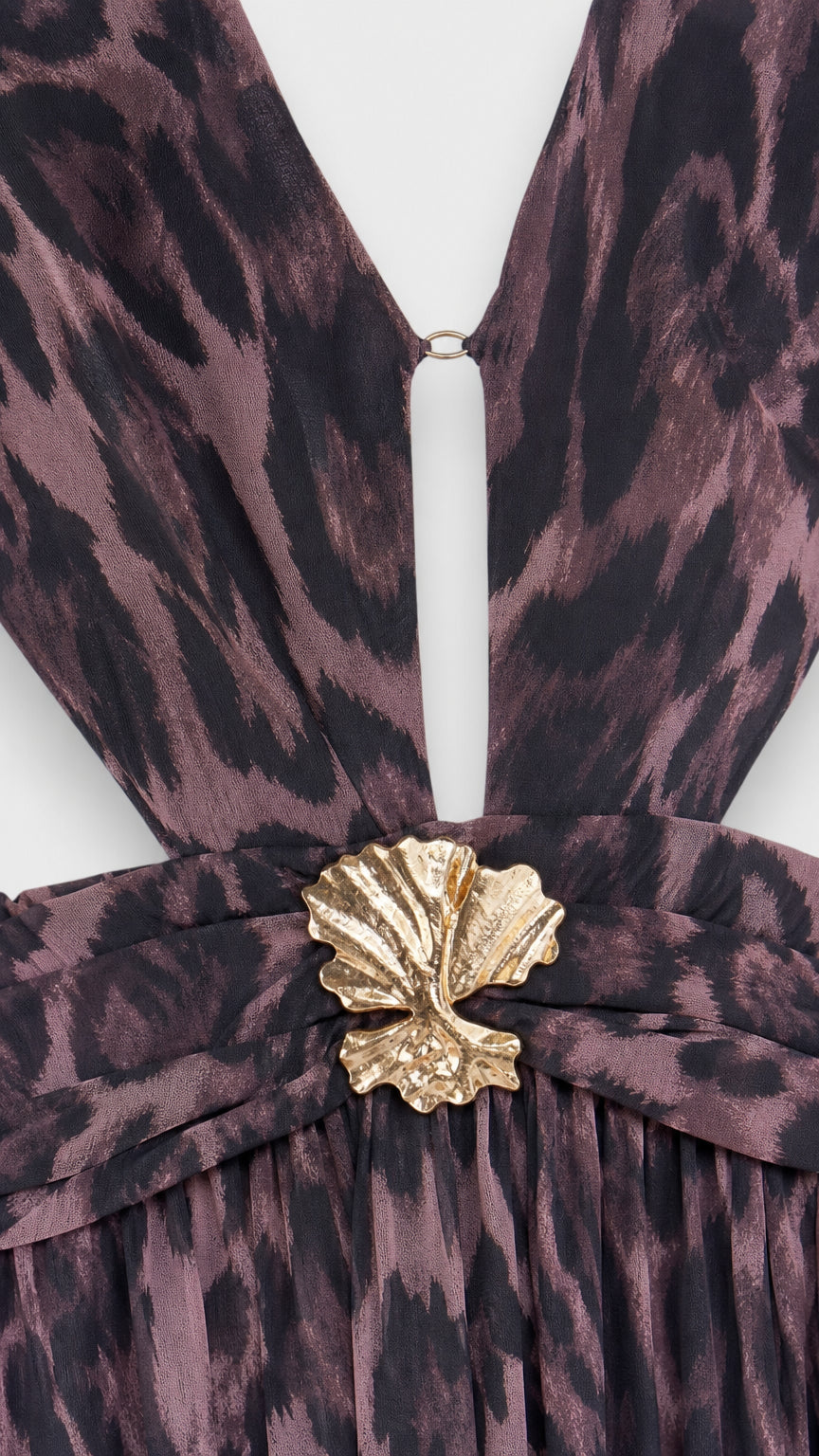 Close-up detail of the plunging neckline, waist cutout, and gold shell hardware