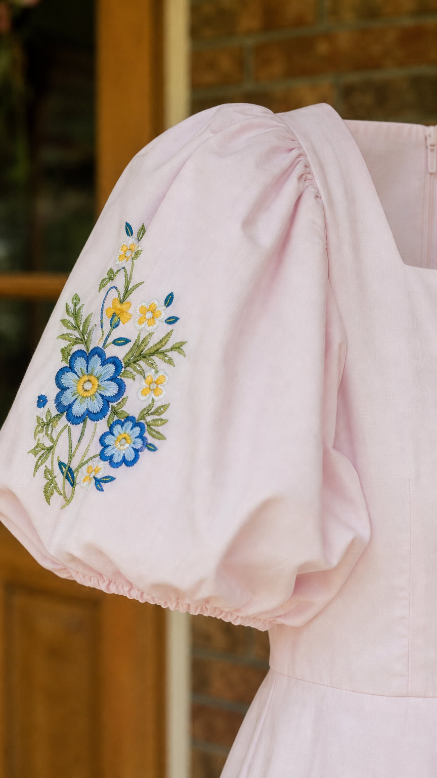 Close-up of sleeve showing blue and yellow floral embroidery details
