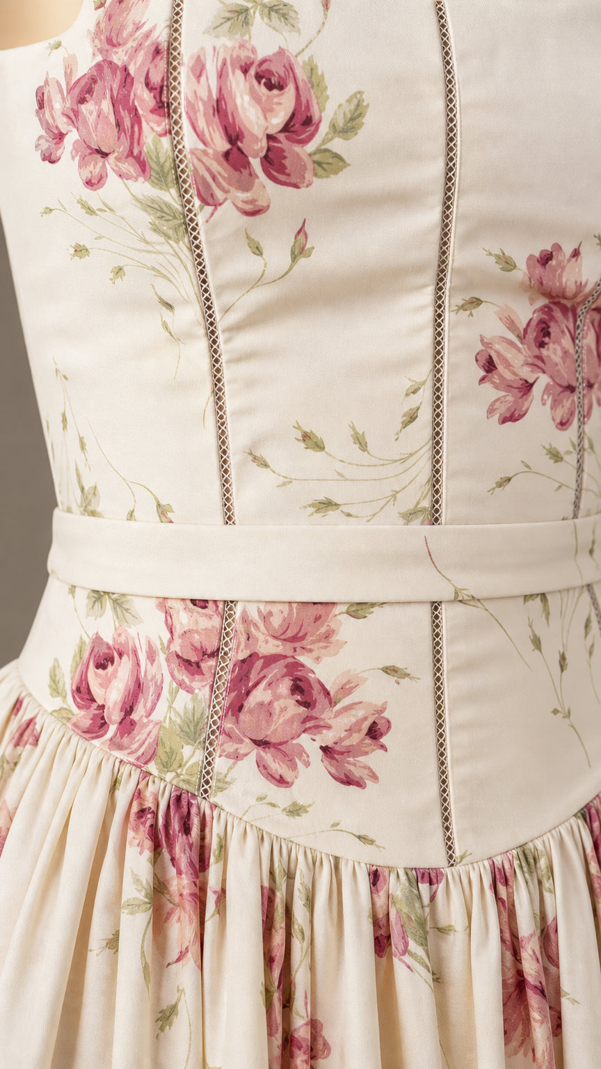 Close-up detail of cream floral dress bodice and waist