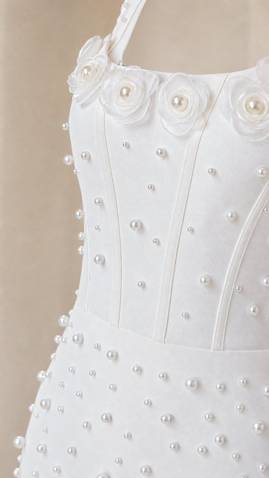 Close up of 3D rosette and pearl bodice details on white dress