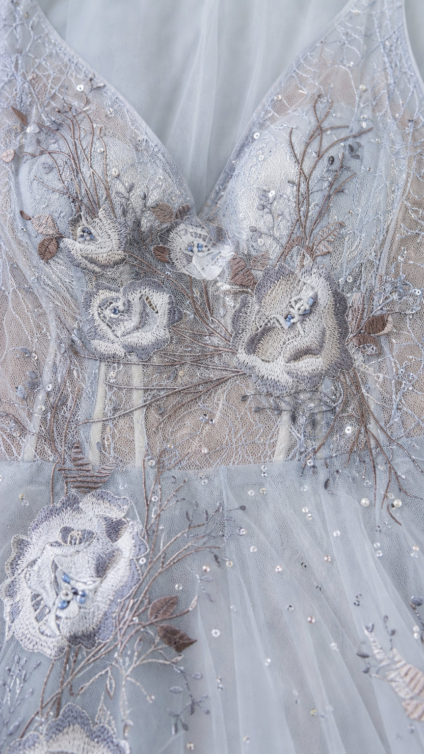 Close-up detail of bodice embroidery and beadwork on light blue gown